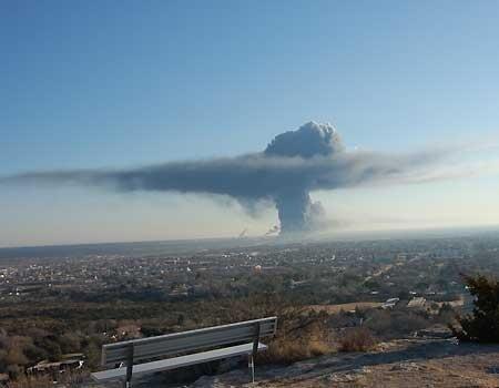 Mushroom cloud, from chemical plant explosion, forms above city from a distance