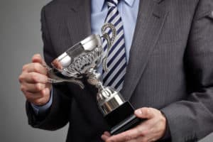 Suited man holding a silver cup