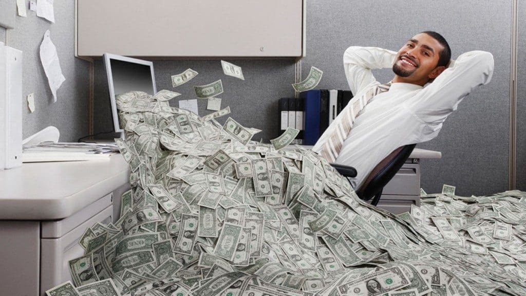 A man at his desk cover with currency