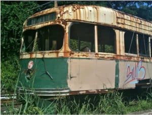Old, rusting streetcar on a side track in the woods