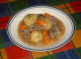 Bowl of soup with potatoes, carrots, and other ingredients