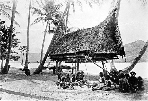 New Guinea natives in 1885 sitting on beach