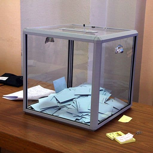 Glass ballot box holding votes 